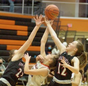 East Central’s Hope Fox (12) and Josie Trabel (23) battle Lawrenceburg’s Katie Johnson (center) for a rebound in the No. 6-ranked Lady Trojans’ 48-22 EIAC title-clinching victory Tuesday night, Jan. 19, at Lawrenceburg.