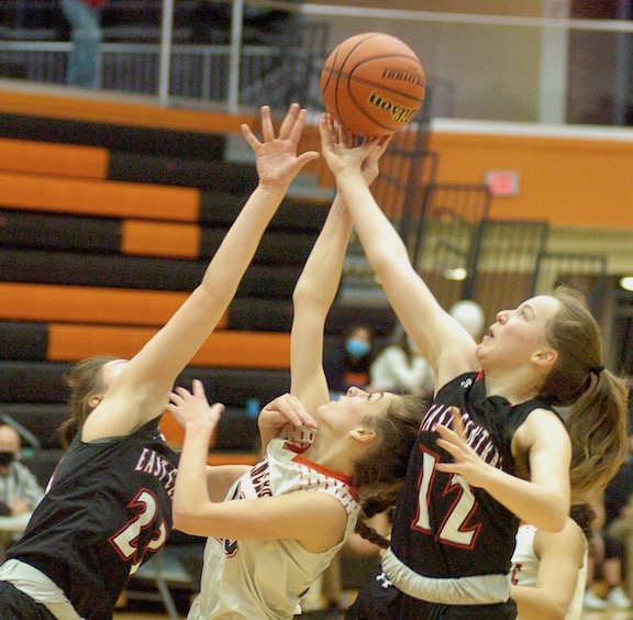 East Central’s Hope Fox (12) and Josie Trabel (23) battle Lawrenceburg’s Katie Johnson (center) for a rebound in the No. 6-ranked Lady Trojans’ 48-22 EIAC title-clinching victory Tuesday night, Jan. 19, at Lawrenceburg.