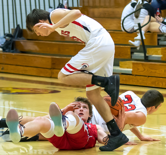 South Dearborn’s Eli Hoffman (bottom) maintains possession of the ball despite a 3-way collision with East Central’s Jadyn Dennis and John Hotel in Wednesday’s 53-36 SD victory. (Sandy Mahoney)