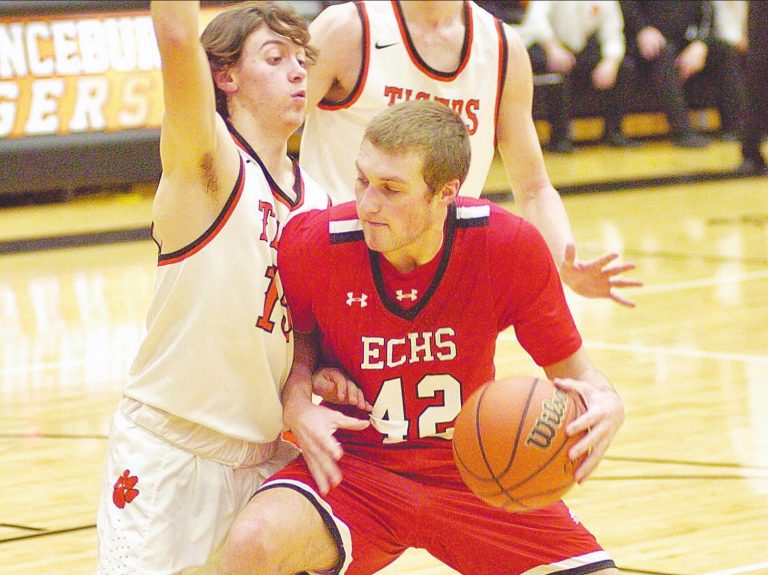 East Central’s Logan Rohrbacher (42), who led all scorers with 22 points, drives to contact with Lawrenceburg’s Reece Denning in the Trojans 38-26 EIAC road Thursday, Feb. 4. JIM BUCHBERGER/THE REGISTER