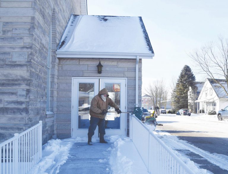 Monte Utter shovels off the walk up to the Dillsboro United Methodist Church Wednesday. He said he was clearing the walkway for the Ash Wednesday services scheduled for later that evening. The pastor of the church is Debbie Bascom. MARC EMRAL/THE REGISTER