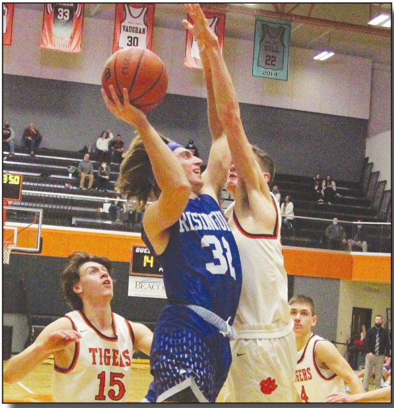 Rising Sun senior guard Landon Cole (32) drives and shoots over Lawrenceburg’s 6’7” Jackson Bobo for two of his game-high 18 points in the Shiners’ 64-50 non-conference loss at LHS Saturday night. MASON J. UHLMANSIEK