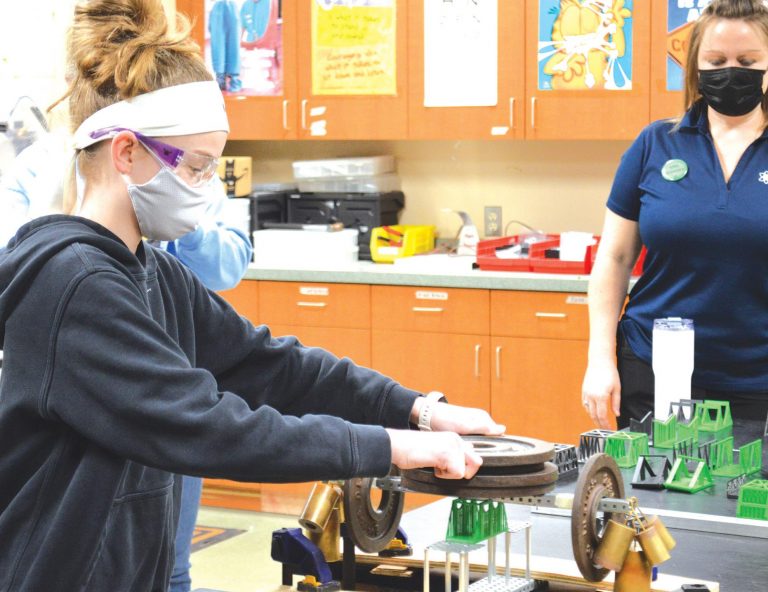 Madison Meibers placed weights on her 3D printed bridge she designed in the STEM class. HALIE BARGER/The Harrison Press