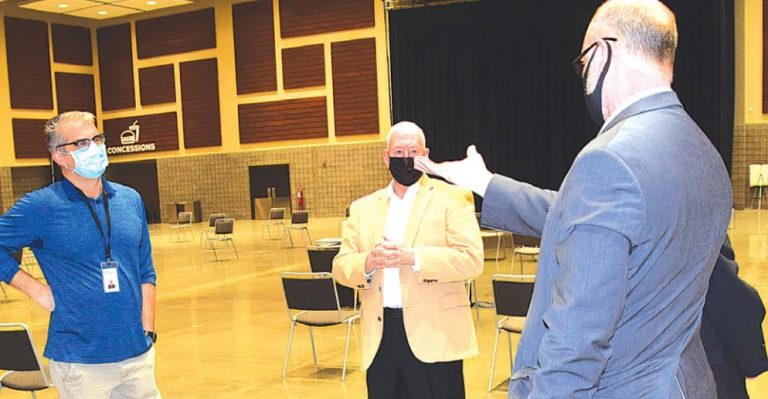 Hollywood Casino general manager Mike Galle, right, makes a point to U.S. Rep. Greg Pence, in brown coat, during the congressman’s visit to the Dearborn County vaccination Clinic March 8. County Health Director Dr. Stephen Eliason is on the left. MARC EMRAL/THE REGISTER