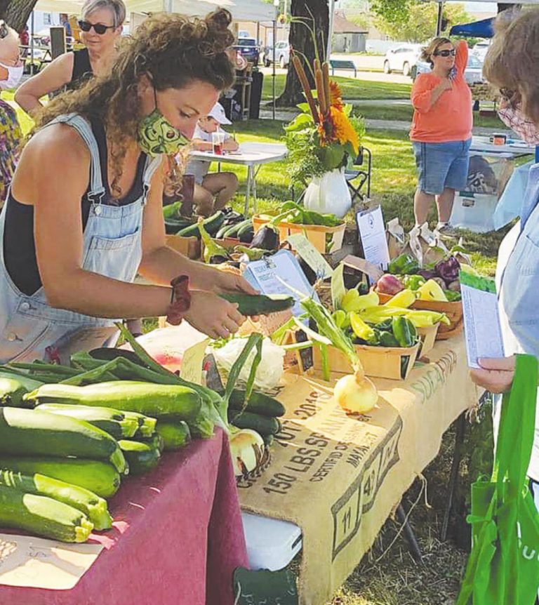 A vendor at a past Lawrenceburg farmers Market sells some of her produce. The market is moving to downtown, opening June 12. SUBMITTED PHOTO