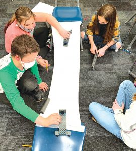 Fourth-grade students at Moores Hill Elementary are testing and observing collisions while recording data to help them design a vehicle restraint system in their science class as part of a Project Lead the Way lesson. Pictured front, from left: Connor Nobbe and Maddi Lanham; back, from left: Nikki Wingate and Izzy Russell. SUBMITTED PHOTO