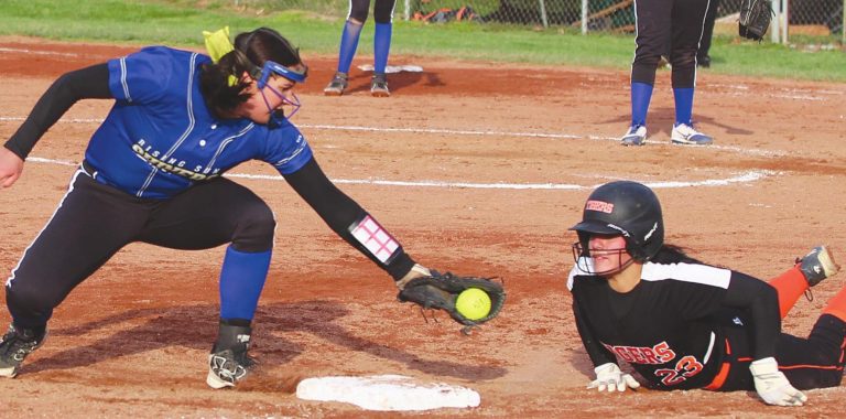 Rising Sun senior Lindsay Montgomery tags out a Lawrenceburg rival attempting to slide back into third base in the Lady Shiners’ season-opening 18-11 slugfest win over the Tigers last Wednesday, March 31, at David & Butch Brown Stadium. MASON J. UHLMANSIEK