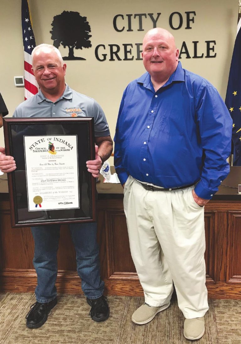 Retired Greendale Police Chief DeWayne Uhlman receives the certificate of Sagamore of the Wabash with his friend and assistant chief Jeff Lane. LAURA A. HOBSON/JOURNAL-PRESS