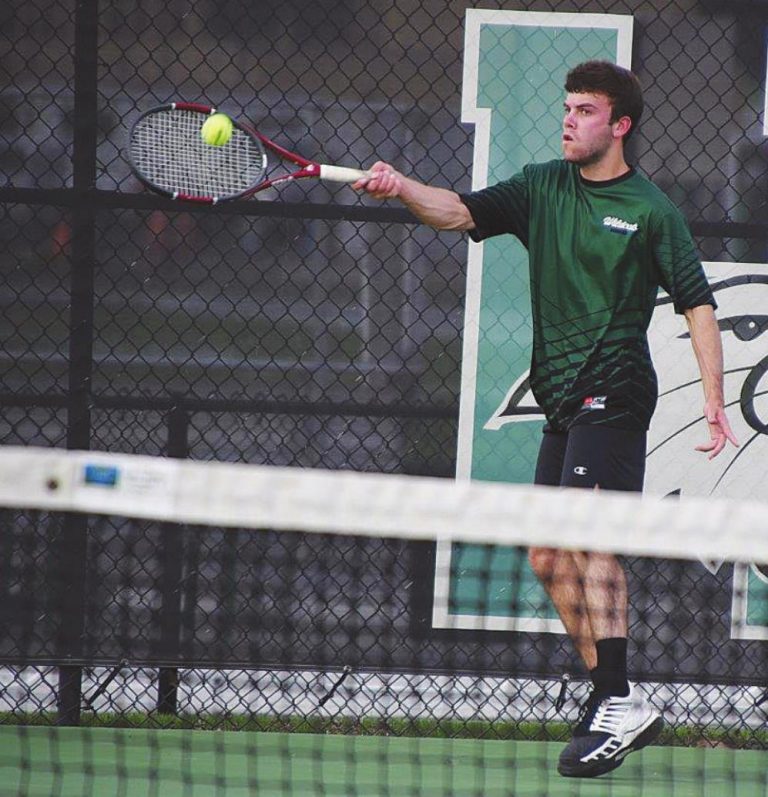 Wildcat Jake Snyder returns a ball during Harrison’s game against Wyoming April 6. PHOTO BY SANDY MINOR