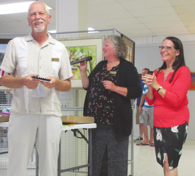 Gary Payne receives an award for his artwork from Marge Beinkemper and Chris Campbell at the 2019 spring show. SUBMITTED PHOTO