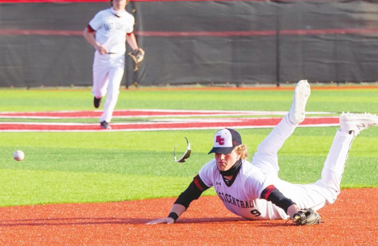 East Central shortstop Carson Koelling (9) loses his sunglasses as he makes a diving attempt to snag a base hit in the Trojans’ 7-5 conference loss to Franklin County Monday. SANDY MAHONEY