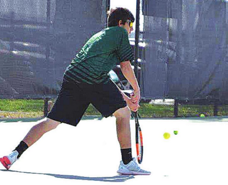 Tyler Ferry returns a shot during his match against Northwest April 19. PHOTO BY SANDY MINOR