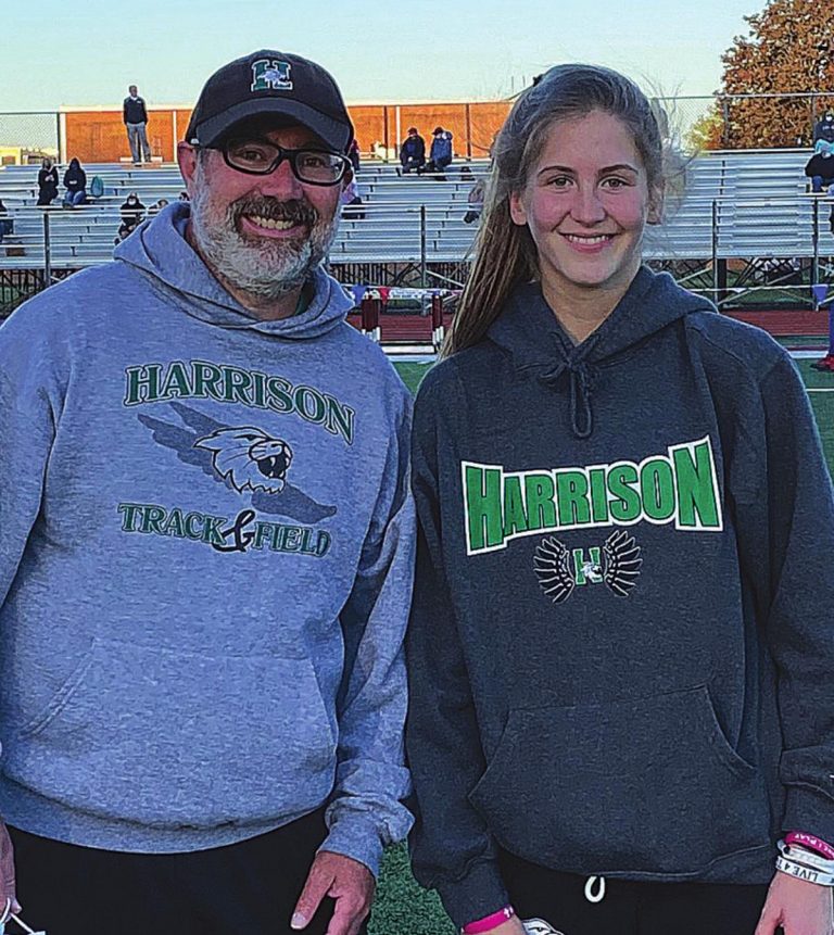 Harrison distance coach Jon Motsinger and freshman Natalie Kiefer after Kiefer set the school record in the 1,600-meter run at the Ross Invitational April 30. PHOTO COURTESY SCOTT MENZE