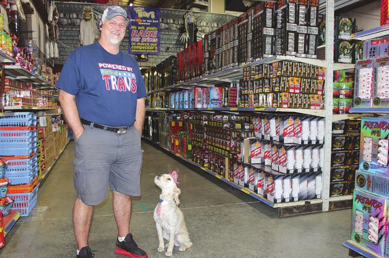 Travis Chrisman, owner of Greendale’s Party At Trav’s Fireworks, like most fireworks retailers, is fully stocked and prepared for the 4th of July rush. He stands with his dog Dexter. MATT POPOVICH/THE JOURNAL-PRESS