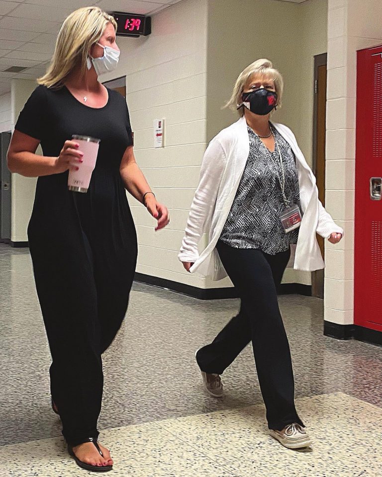 Jamie Rosfeld, left, East Central High School assistant principal, and Linda Ascherman, ECHS administrative assistant, walk the halls of the high school to exercise. A PHOTO BY SPENCER POWELL