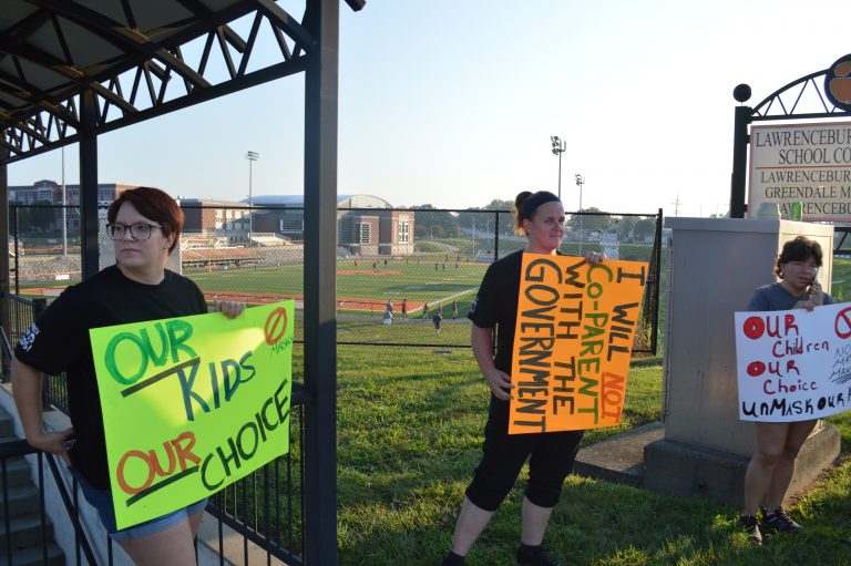 Halie Barger/The Journal-Press  Abbey Folke, Victoria Hogan and Tara Abdon stood at the entrance to Lawrenceburg schools protesting the recent mask requirement.